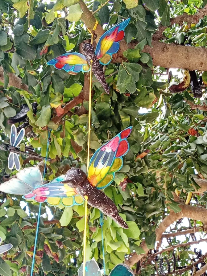 Colourful butterflies hanging in a leafy tree